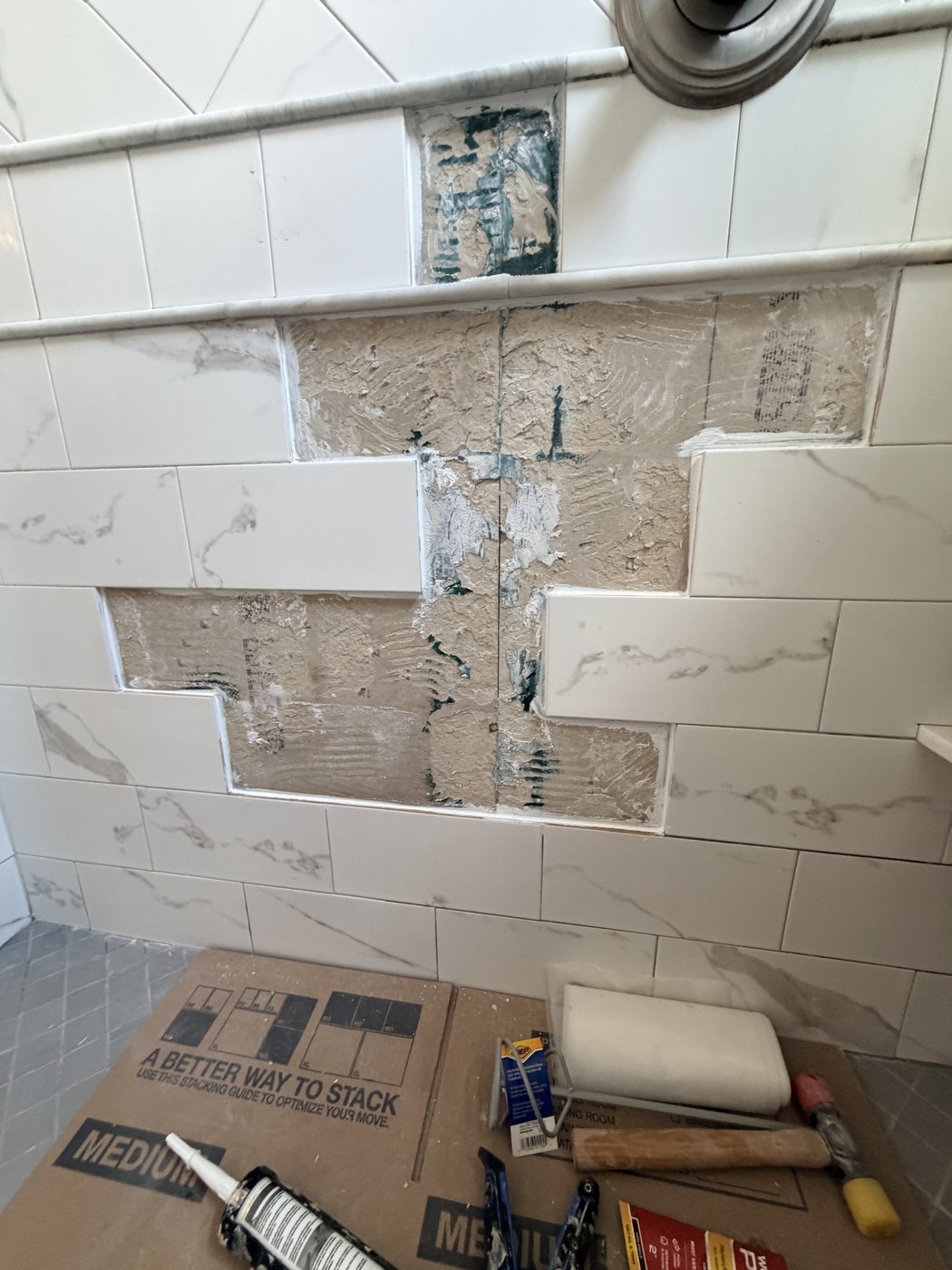 Backer board cleaned up with waterproof sealant installed around the perimeter of the untouched tile