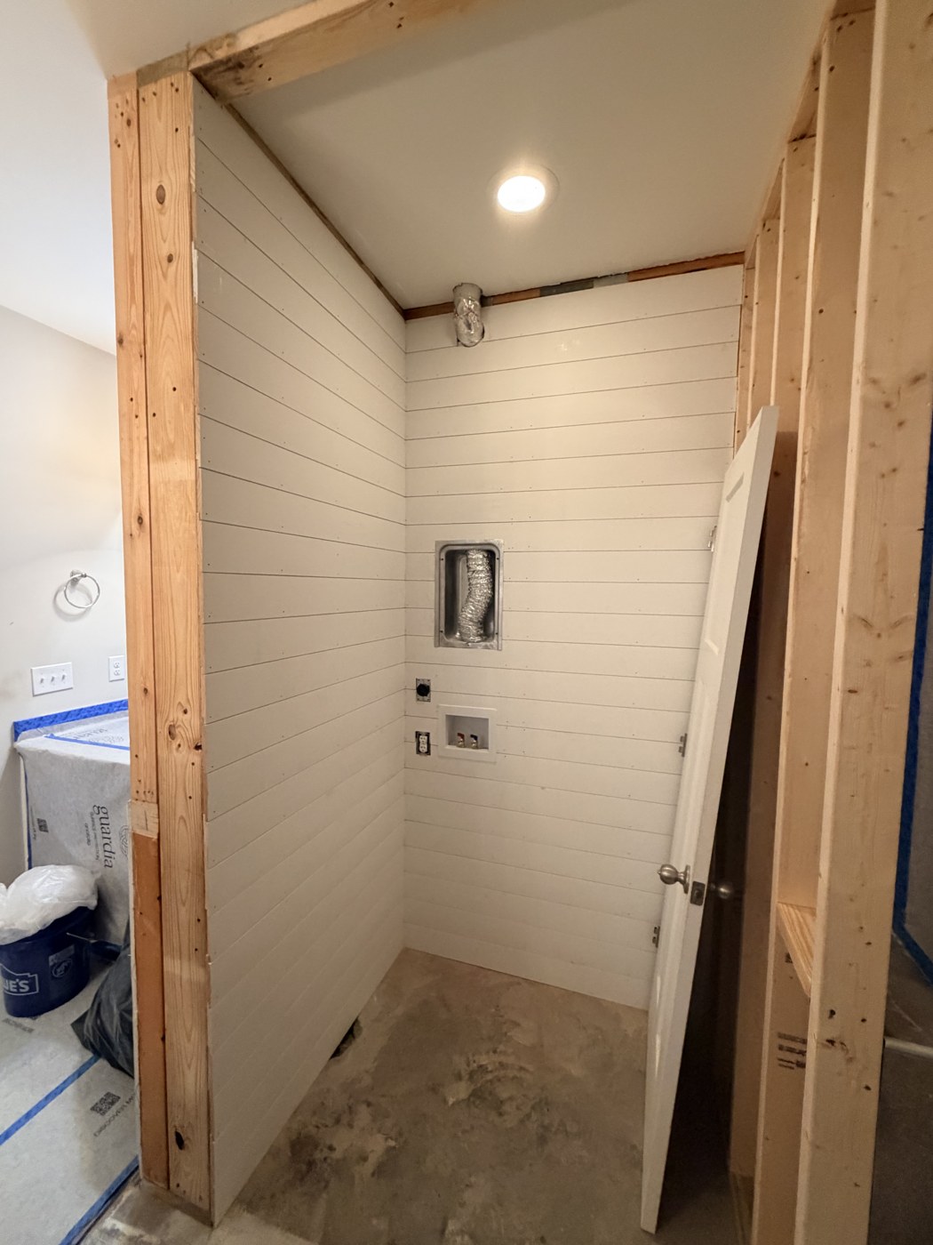 Shiplap up and the concrete slab still exposed before the tile went in, in a laundry closet built where a garden tub used to be, by Tile Yoda in Taylors, SC